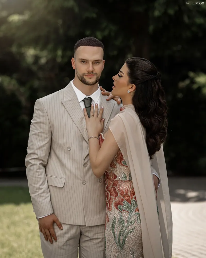 Portrait of a couple in a garden, he in a cream suit, she in an embroidered gown